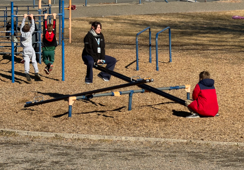 A staff member on a teeter totter with a student