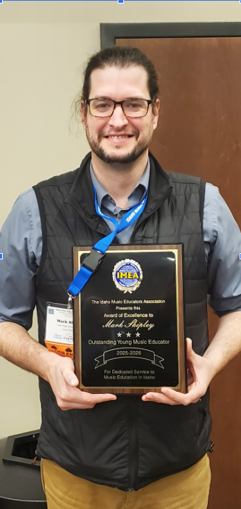 Teacher standing holding a plaque