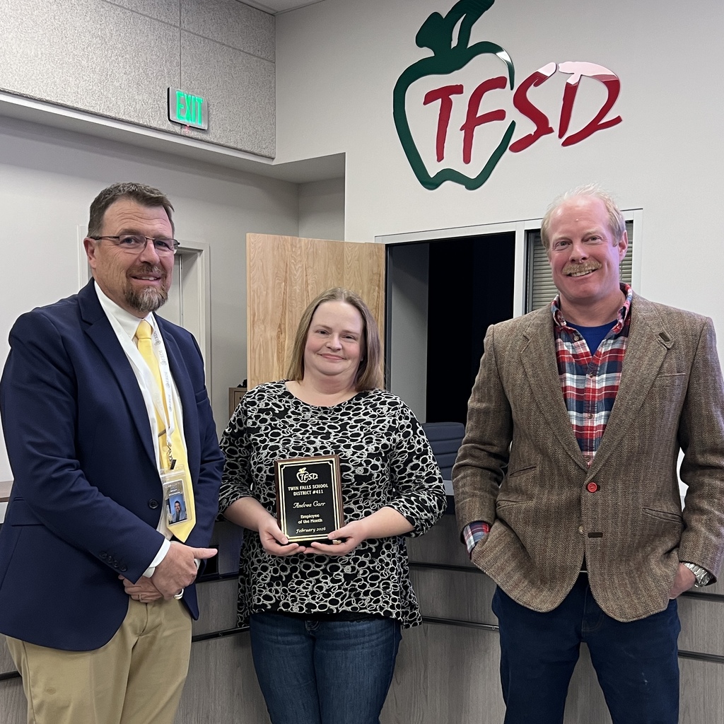 Teacher holding plaque standing with school board members