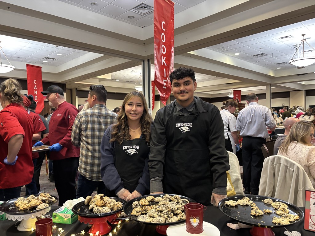 Students pictured standing behind a table displayed with treats