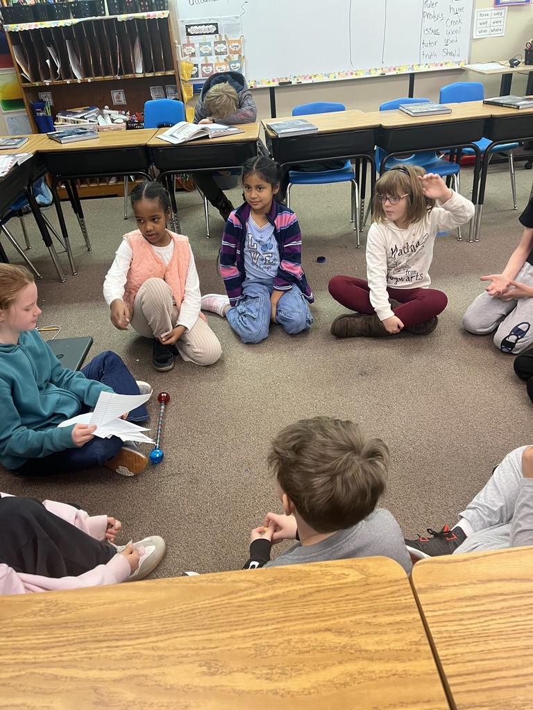 4th graders sit in a circle and discuss bills in a legislative scenario.