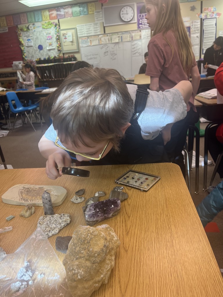 Using a magnifying glass to observe a rock