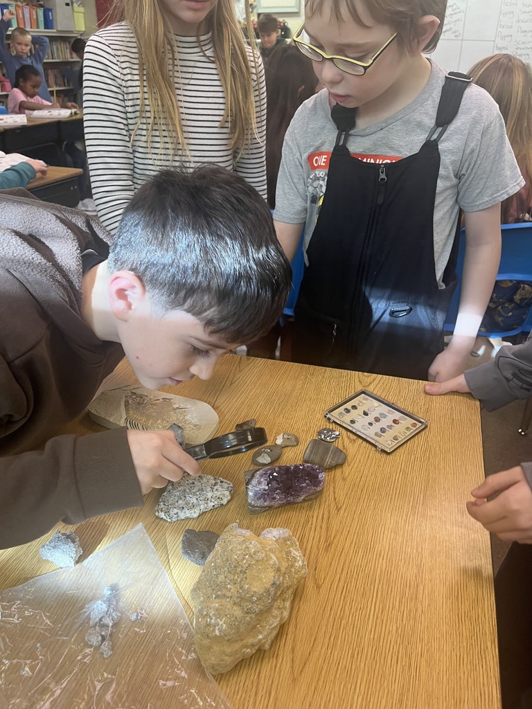 Using a magnifying glass to observe a rock