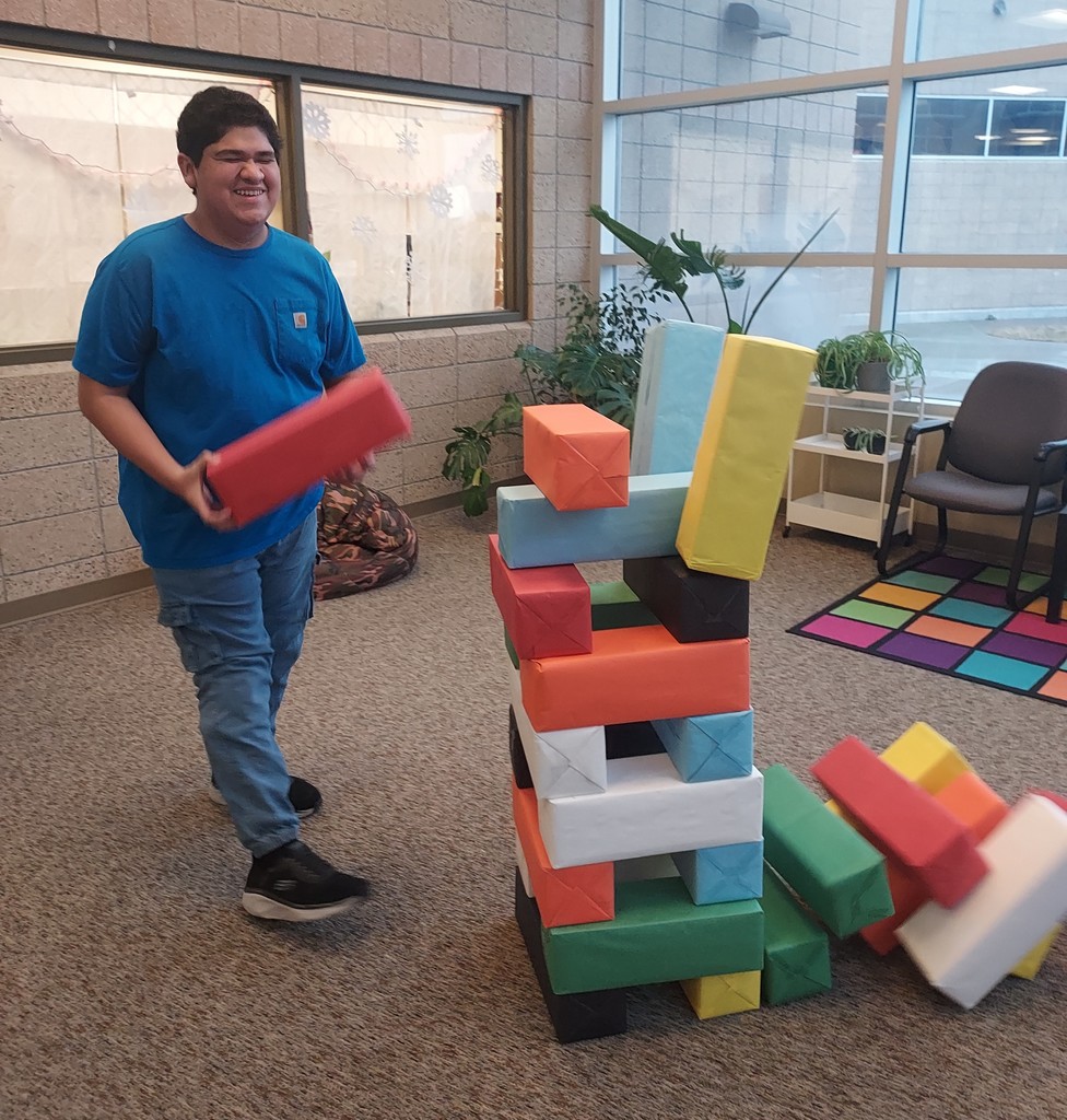 A student smiling enthusiastically while playing giant jenga