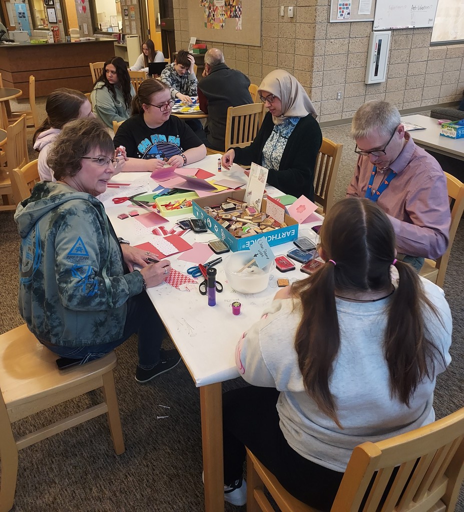 Staff and students filling a table making Valentine's Day Cards