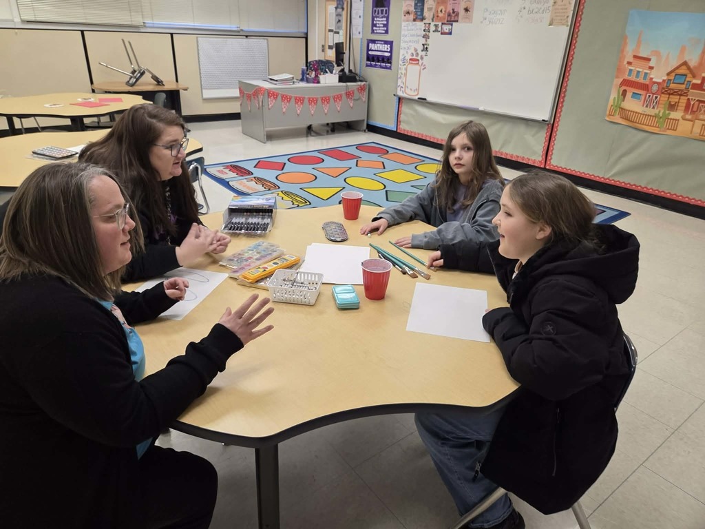 Mrs. Barrow and Miss Young help students create art.