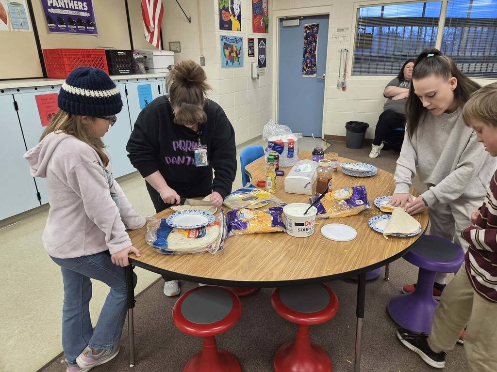 Miss Adamson helping students make quesadillas