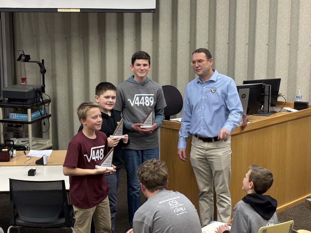Three students pictured with  triangle shaped trophies