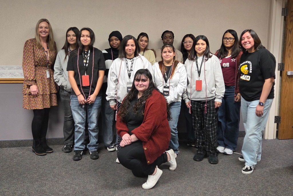 Group pictured with their newly obtained graduation cords draped around their necks