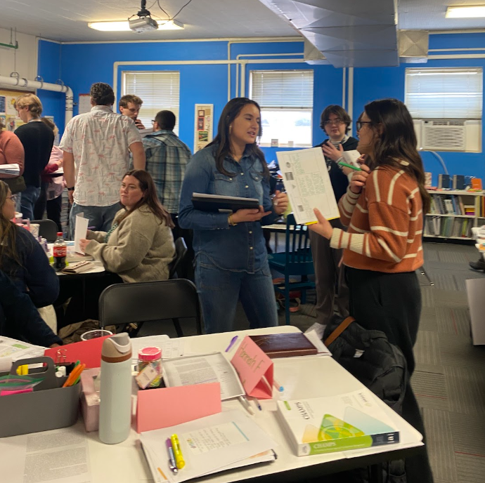 Teachers, Senior and Novice, meandering around a classroom engaged in an activity together