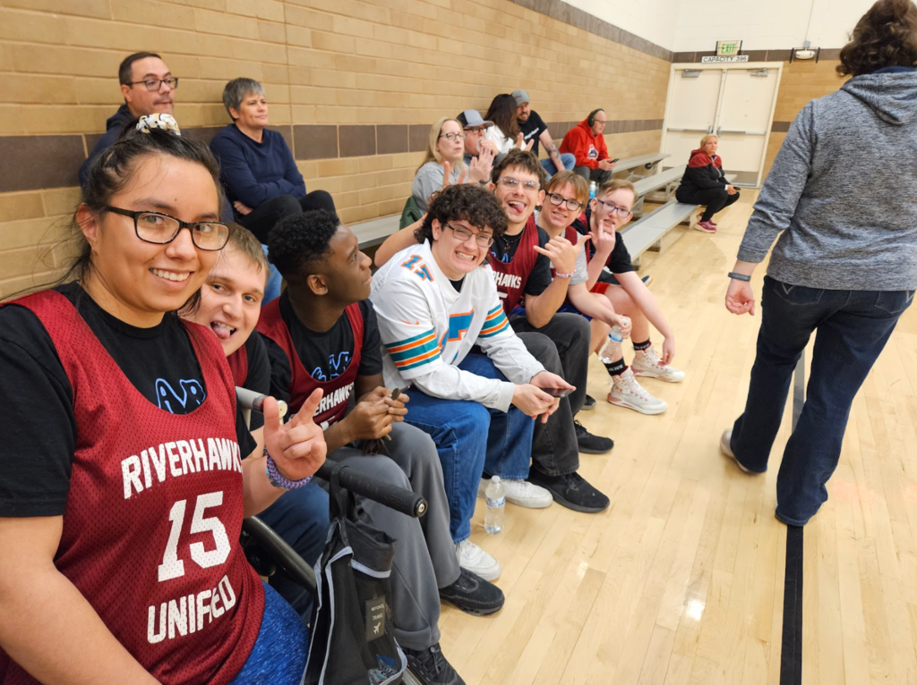 The team lined up sitting the the bleachers smiling for the picture