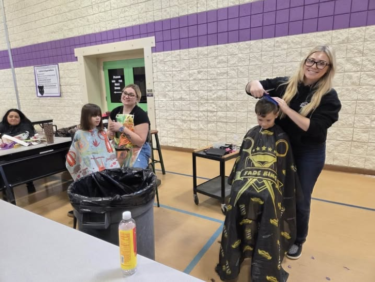 Students getting hair cuts in the school gym
