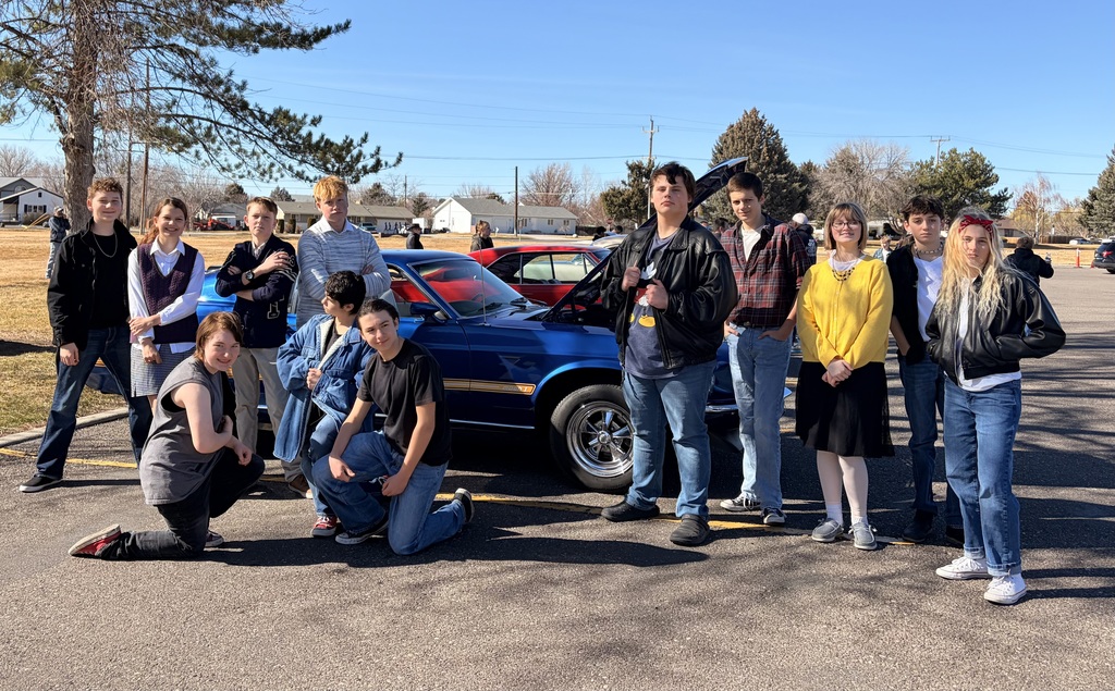 Students dressed up with an old car