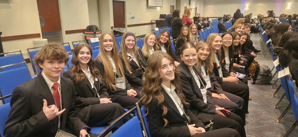 Students in blazers sit on beautiful blue chairs