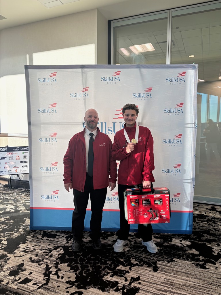 Miguel and his advisor pictured with Miguel holding a prize and wearing a medal