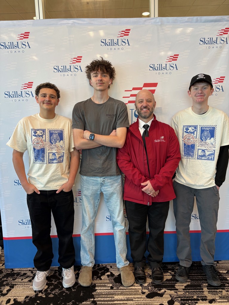 Three students and their advisor in front of a SkillsUSA backdrop