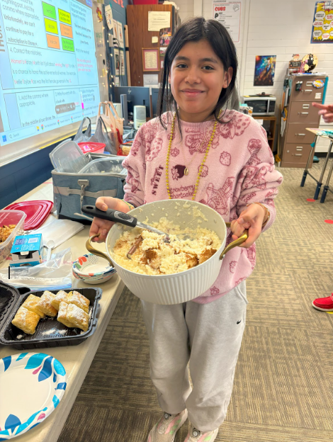 A student holding out a bowl filled with her cultural creation