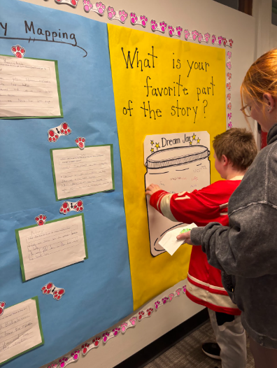 A student and their trusted adult at the "What was your favorite part of the story?" station of the night