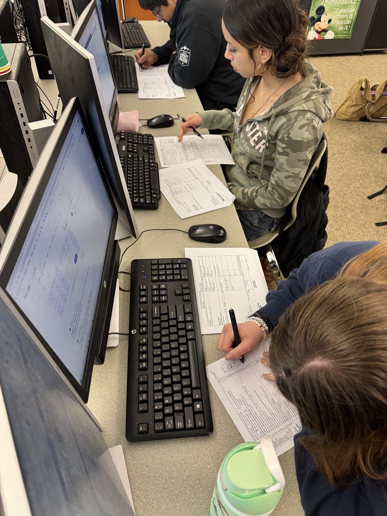 Students at tables filling out tax documents
