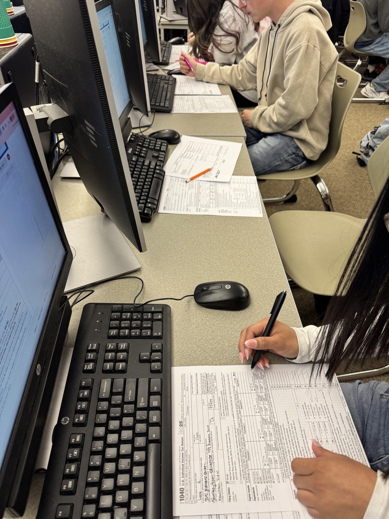 Students at tables filling out tax documents