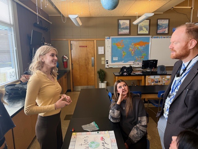 A student explaining their game to a teacher