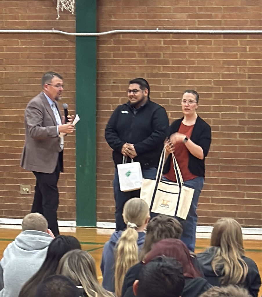 a picture of a teacher getting an award in a school gym.