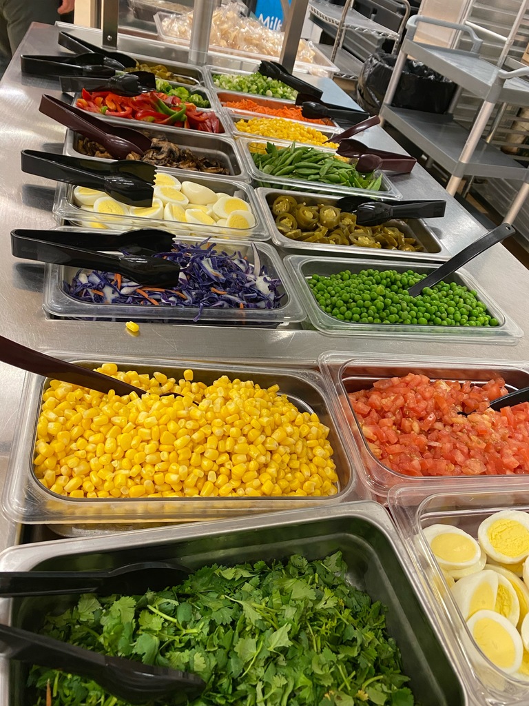 metal cafeteria trays filled with veggies and hardboiled eggs