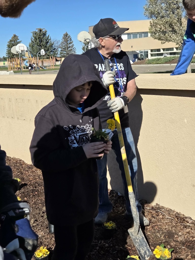 Student planting flowers with Mr. Theo