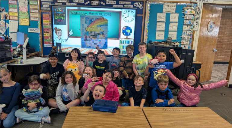 A class grouped together and pictured smiling, very excitedly