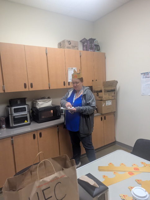 A staff member standing in the lounge with a Burger King crown on her head.