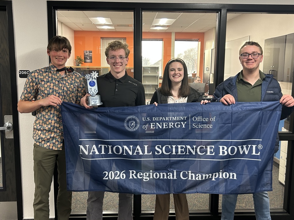 Four students pictured displaying a trophy and banner that reads "National Science Bowl 2026 Regional Champion""