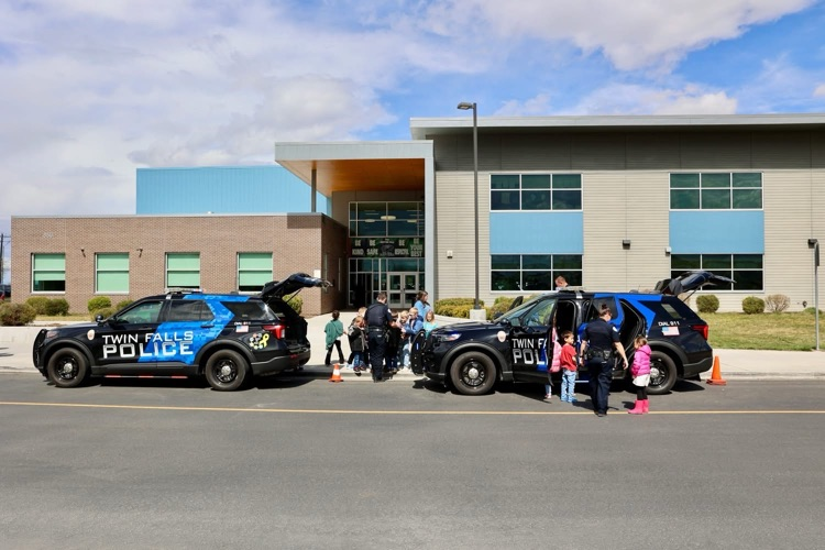Students gathered around a police officers’s vehicle