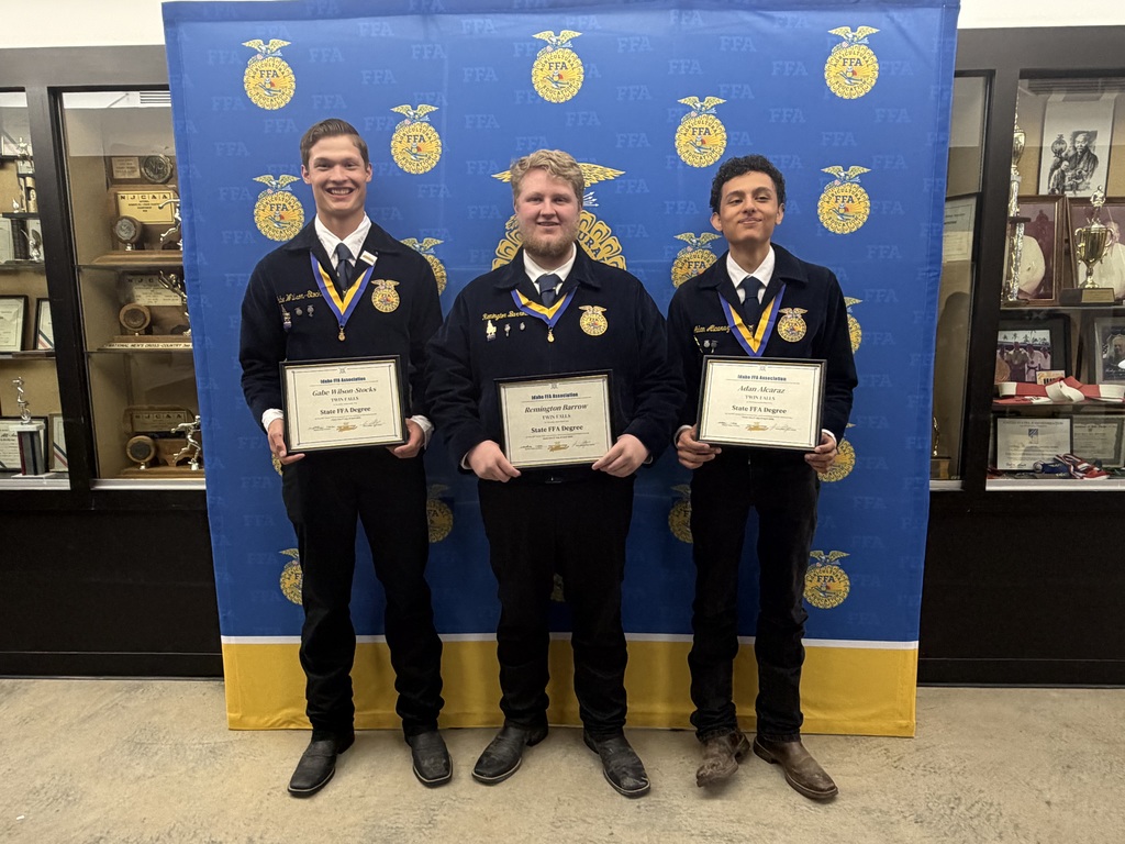 3 FFA male students stand proudly showcasing their state degrees they earned