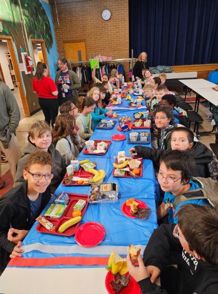 A decorated cafeteria table lined with kids having breakfast to fuel up for testing