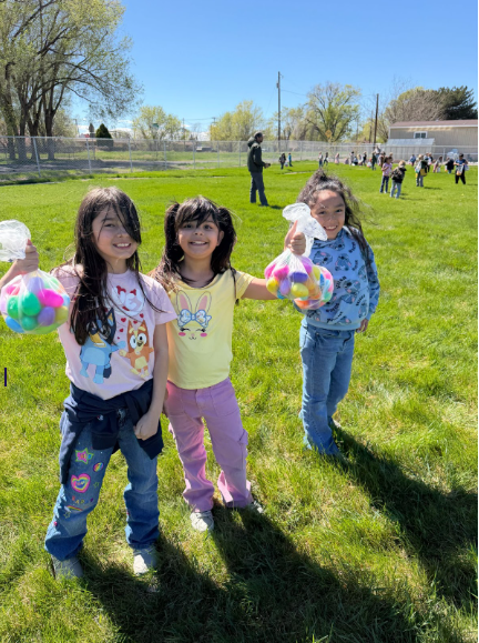 Three students holding up their egg hauls, reminiscent of the way men hold a fish for a profile picture