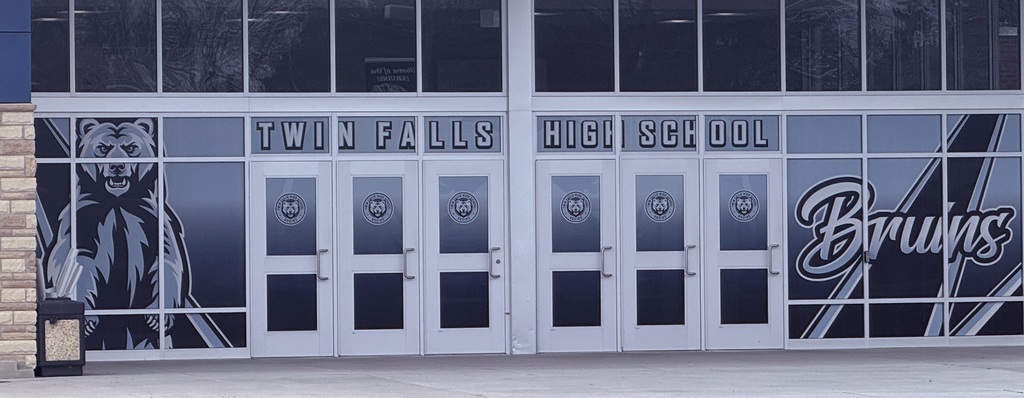 Glass windows are covered with window wrap of a standing bear and Twin Falls High School