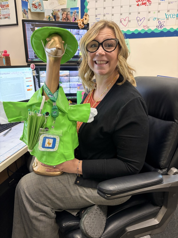 Picture of school secretary, holding the golden goose award