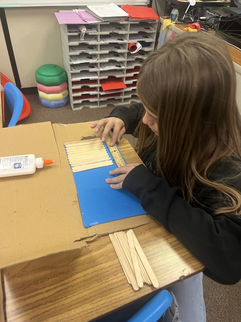 Student measuring popsicle sticks