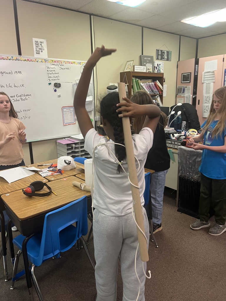 Students measuring with yard sticks as they build inventions