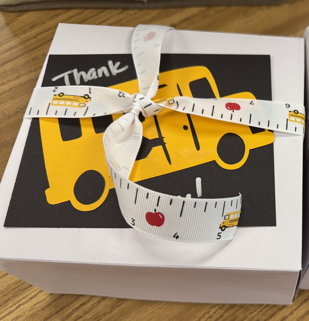 A white box with ribbon and a yellow bus cutout