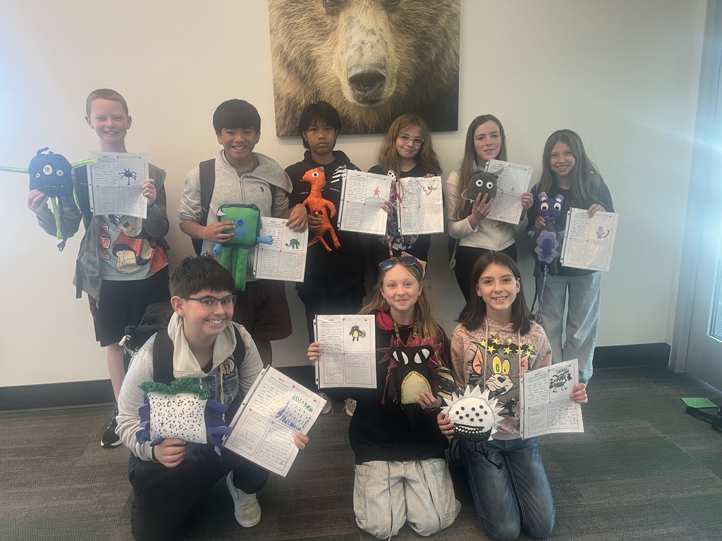 Robert Stuart students smiling with their stuffed animals and writing.