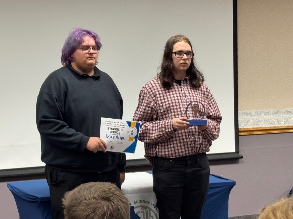 Two students pictured receiving  a "Student's Choice" Trophy and certificate.