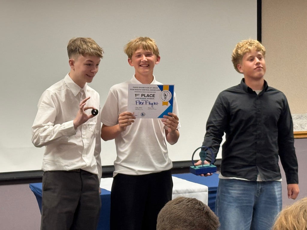 Three students pictured receiving  a "1st Place" Trophy and certificate.