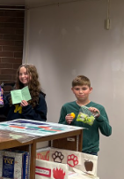 Two students showing their books and prizes to the camera
