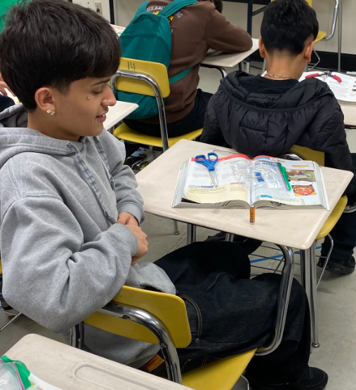 Two students seated at their desks, working on their experiments.