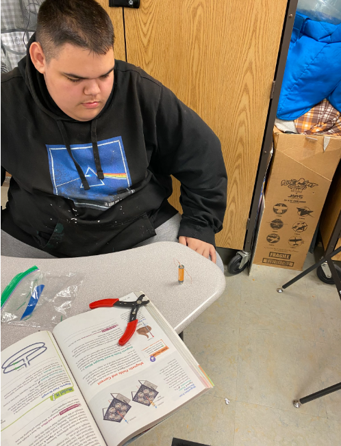 A student seated at his desk working on his experiment.