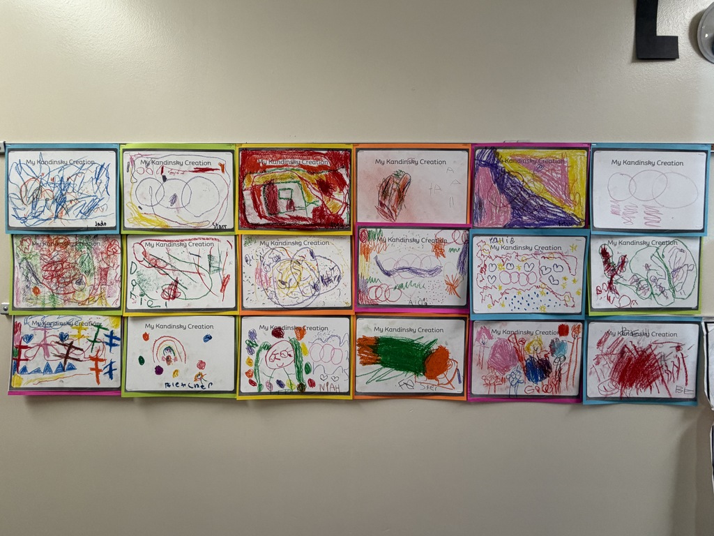 A row of colorful drawings is displayed on a white wall. Each drawing has a blue border.