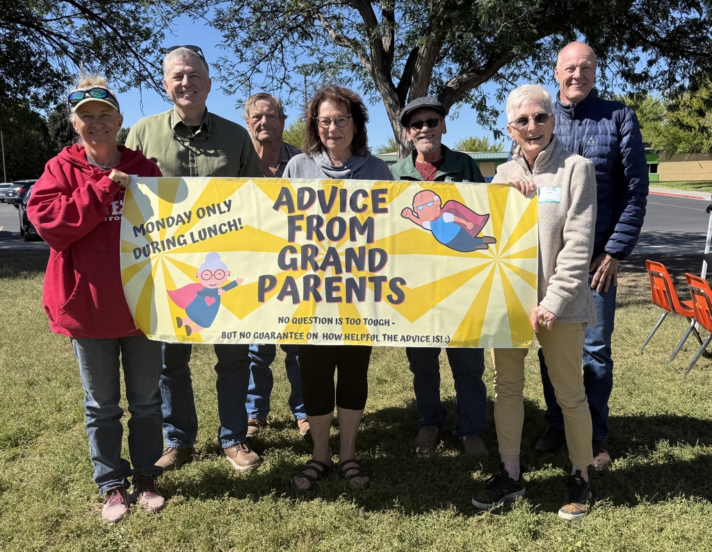 a group picture of seven adults holding a yellow banner