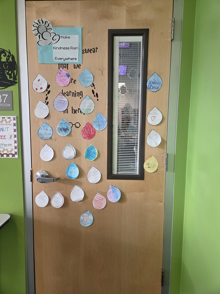 A wooden door with a glass window, adorned with colorful paper raindrops. Green background.
