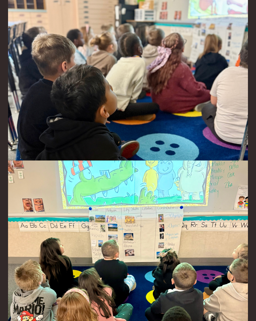 Two groups of children sit on a carpeted floor, listening. One group watches a monitor showing a cartoon.